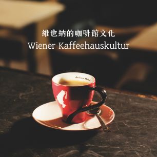 咖啡館桌面上的一杯 Julius Meinl 紅色咖啡杯，背景模糊，上方有「維也納的咖啡館文化 Wiener Kaffeehauskultur」中德文標題。